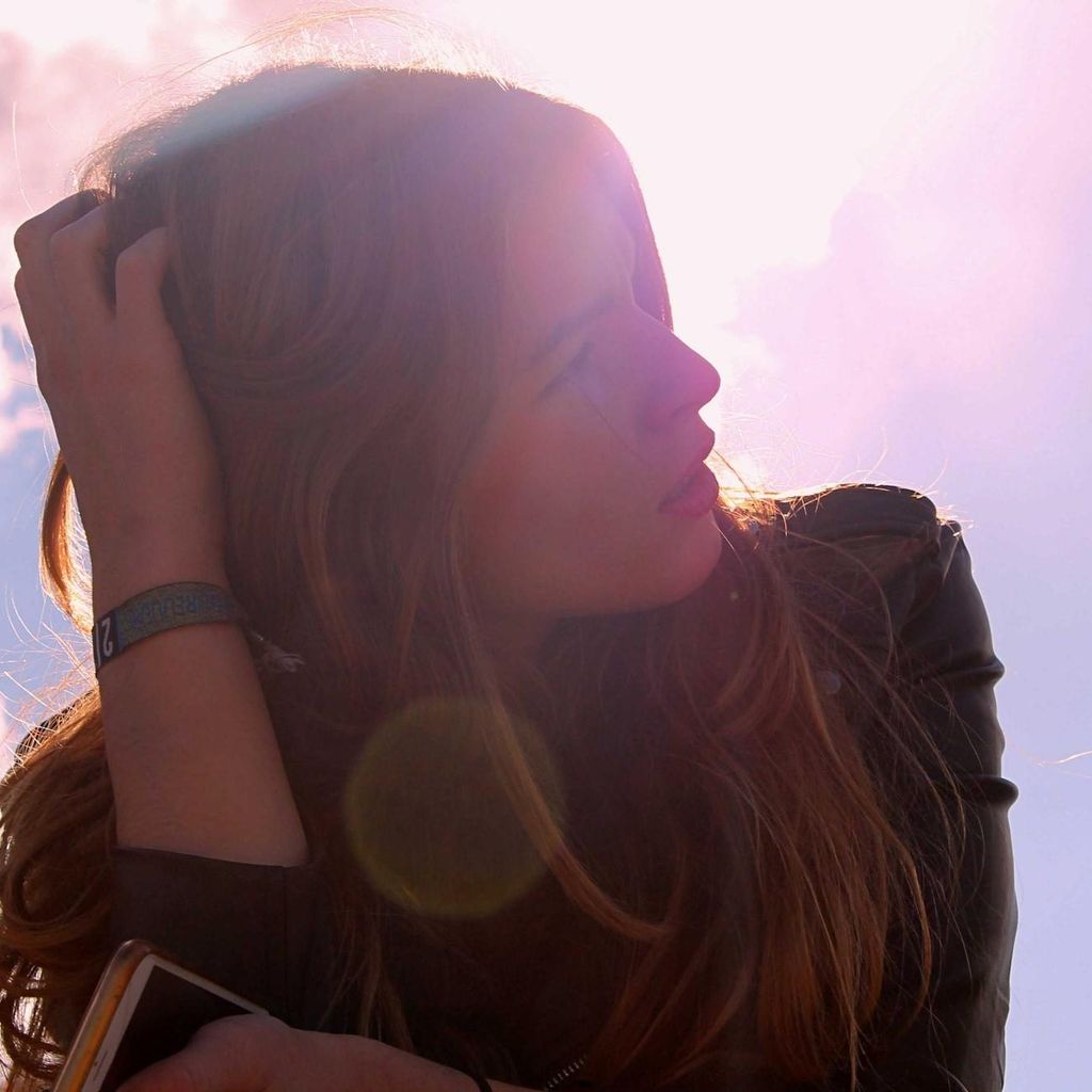 Een vrouw met lang golvend haar in het tegenlicht